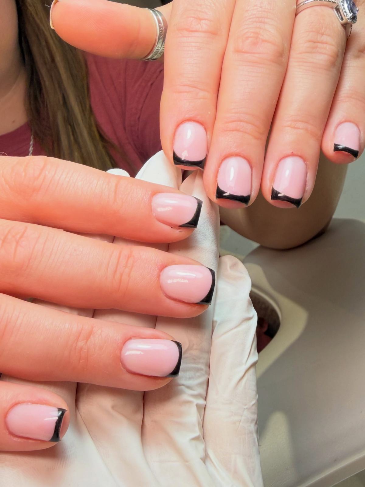 Short square pink nails with black French tips